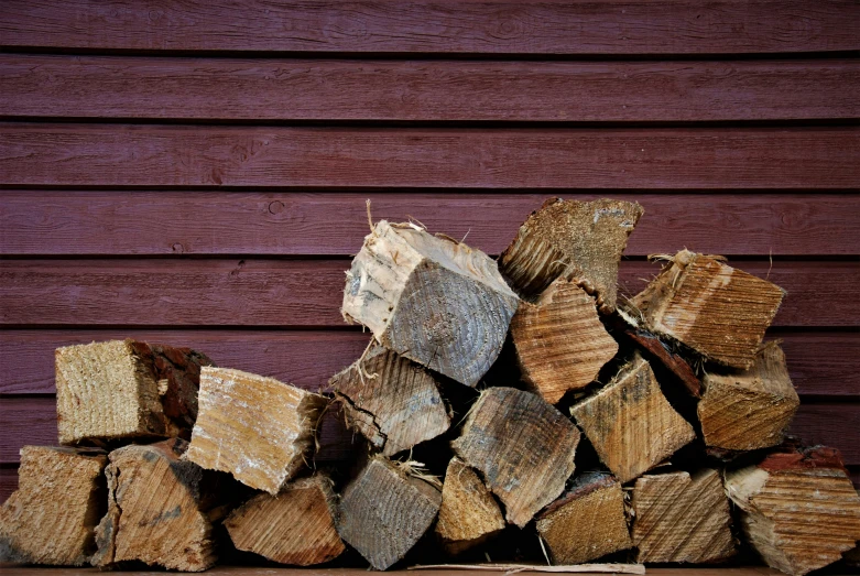 a pile of wood sits next to the side of a building