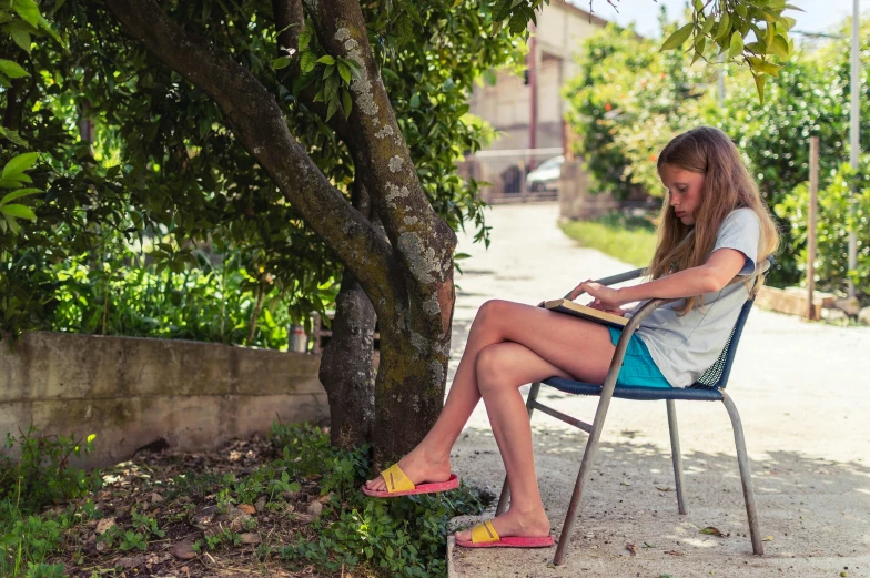 a girl sitting in a chair and writing