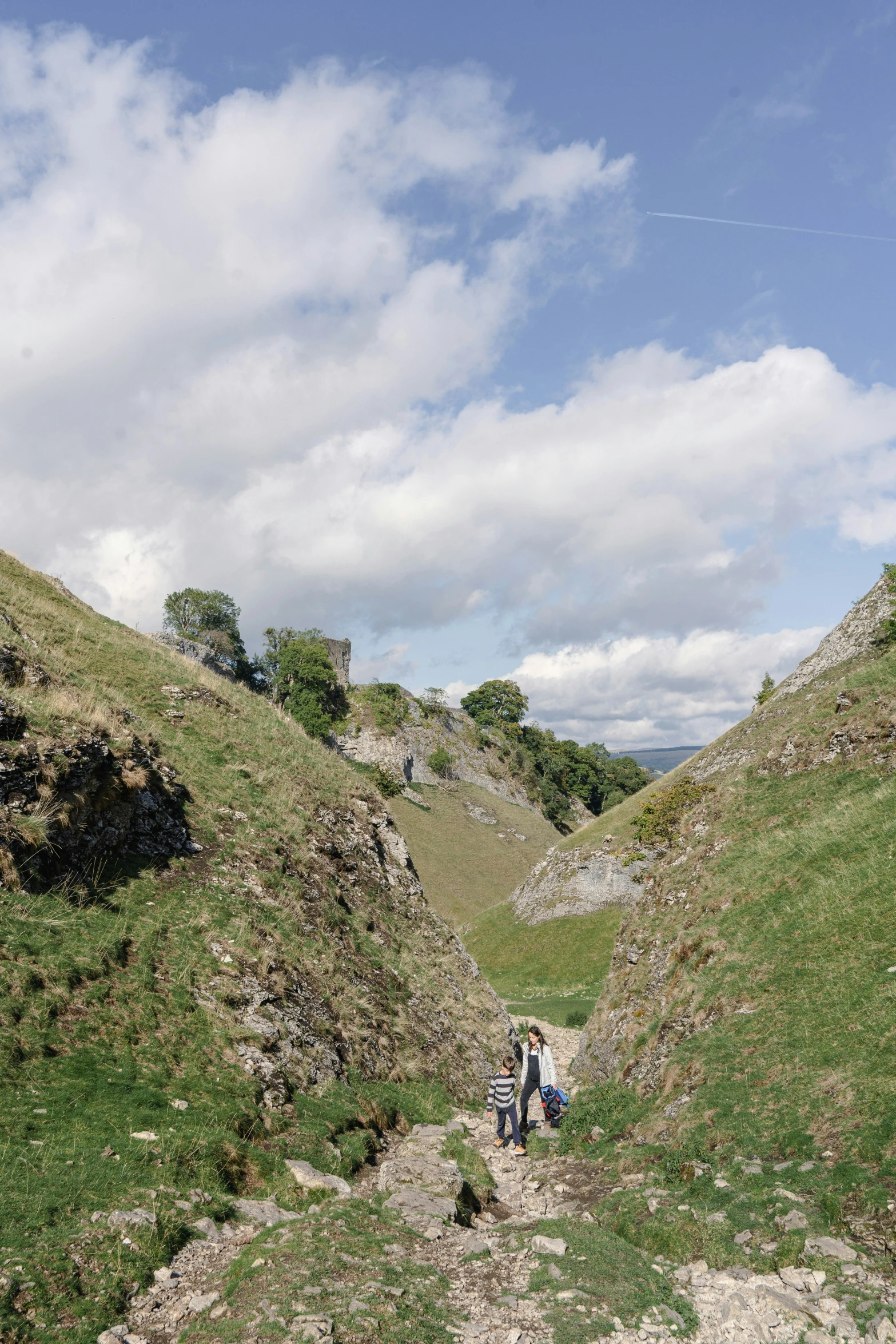 there are two people standing on the side of a hill