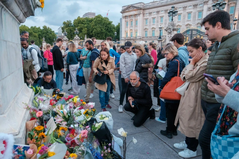 people stand around at a memorial in a town square