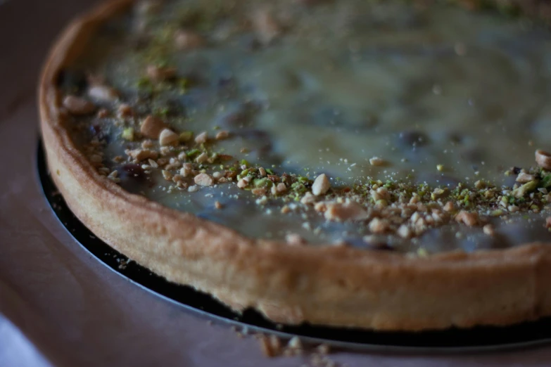 a green topping on a pie sitting on top of a table