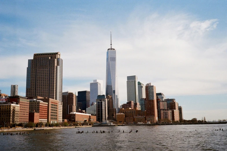 a city view of a river with a boat and a large tall skyscr