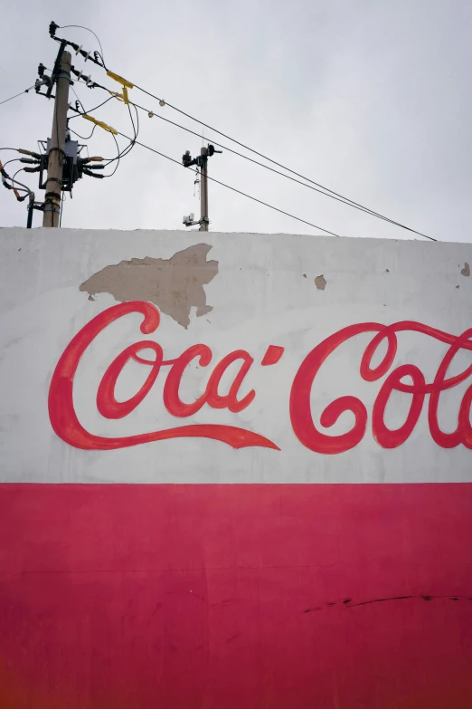 a giant coca - cola sign is painted on to the side of a building