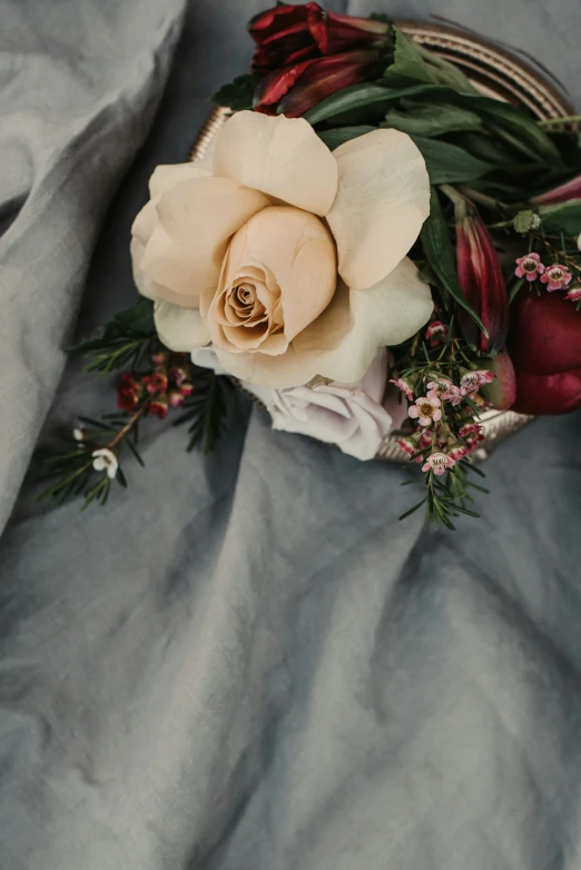 a flower arrangement on top of a cloth on a table