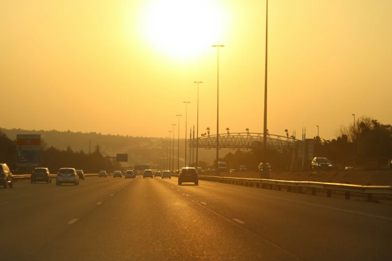 a sunset over an empty freeway with traffic in it