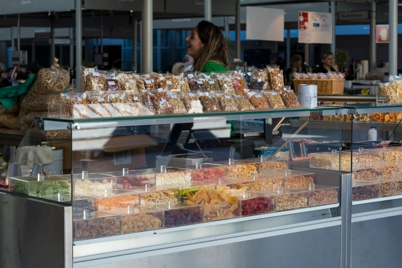 the woman is walking in front of the shop filled with goods