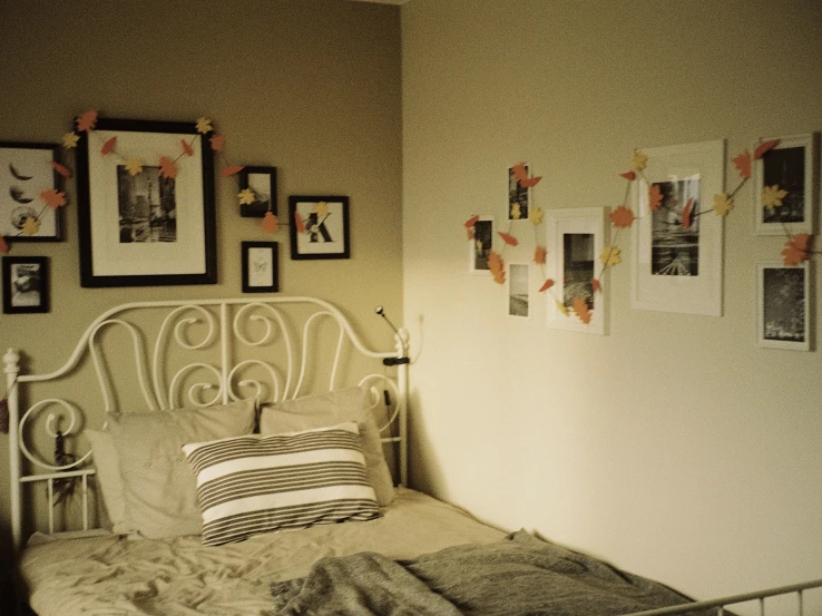 a bedroom that has many pictures hanging on the wall