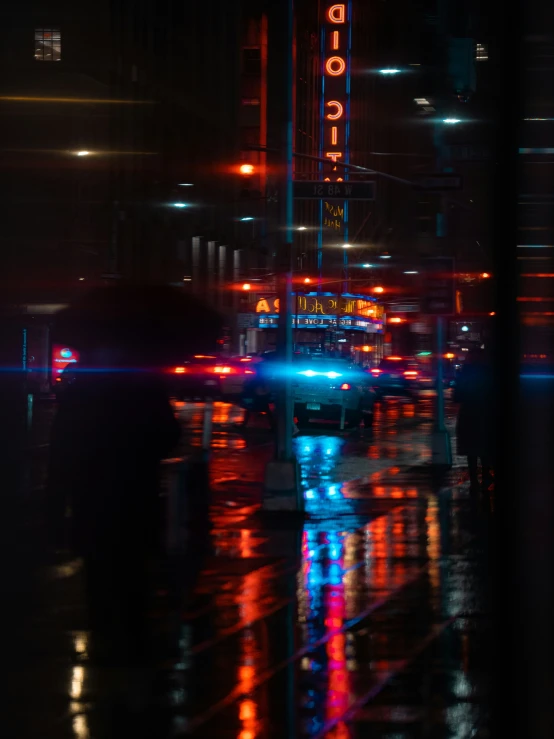 a city street at night with traffic passing through the intersection