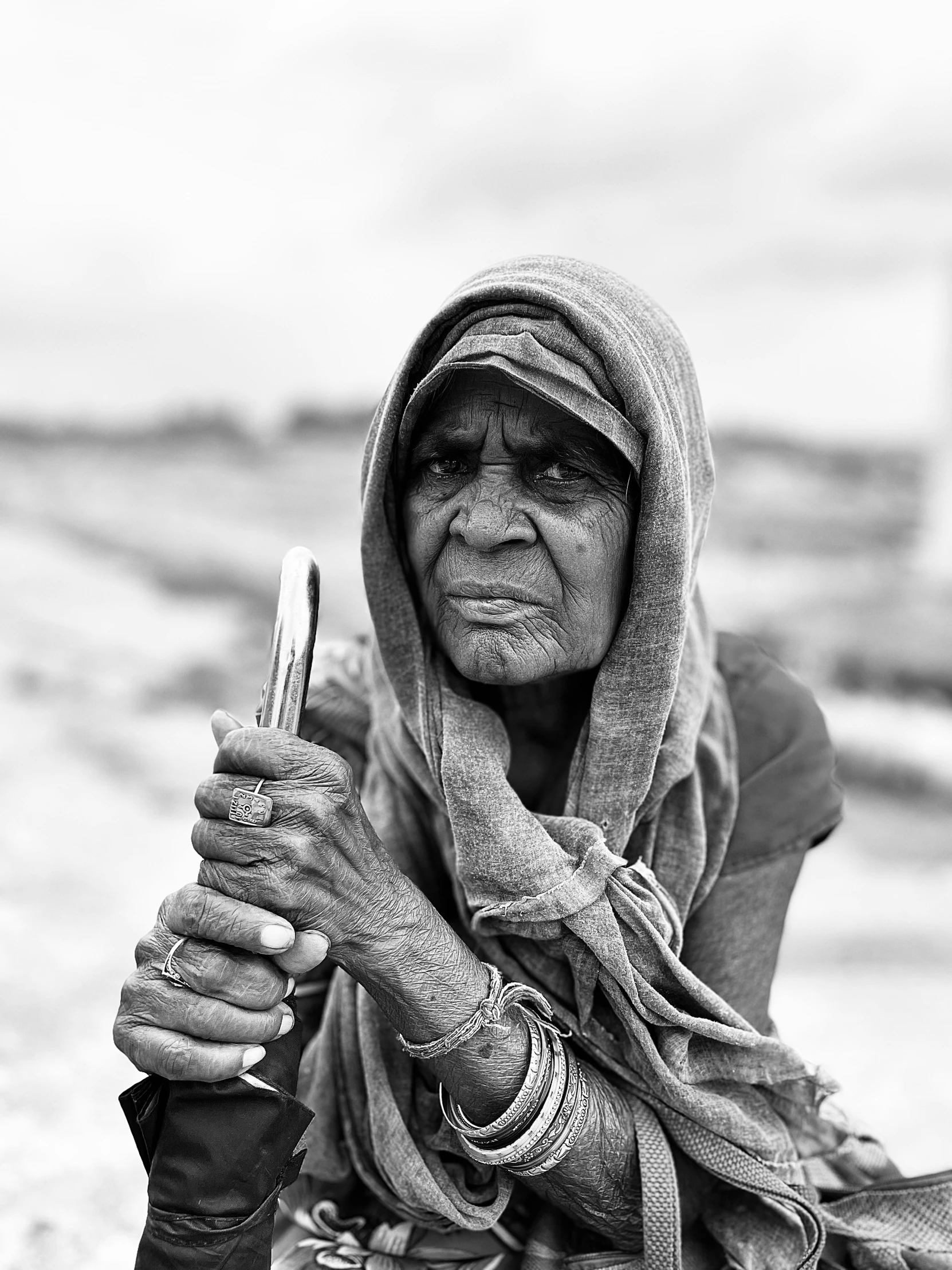 an old woman holds up her cell phone to take a picture