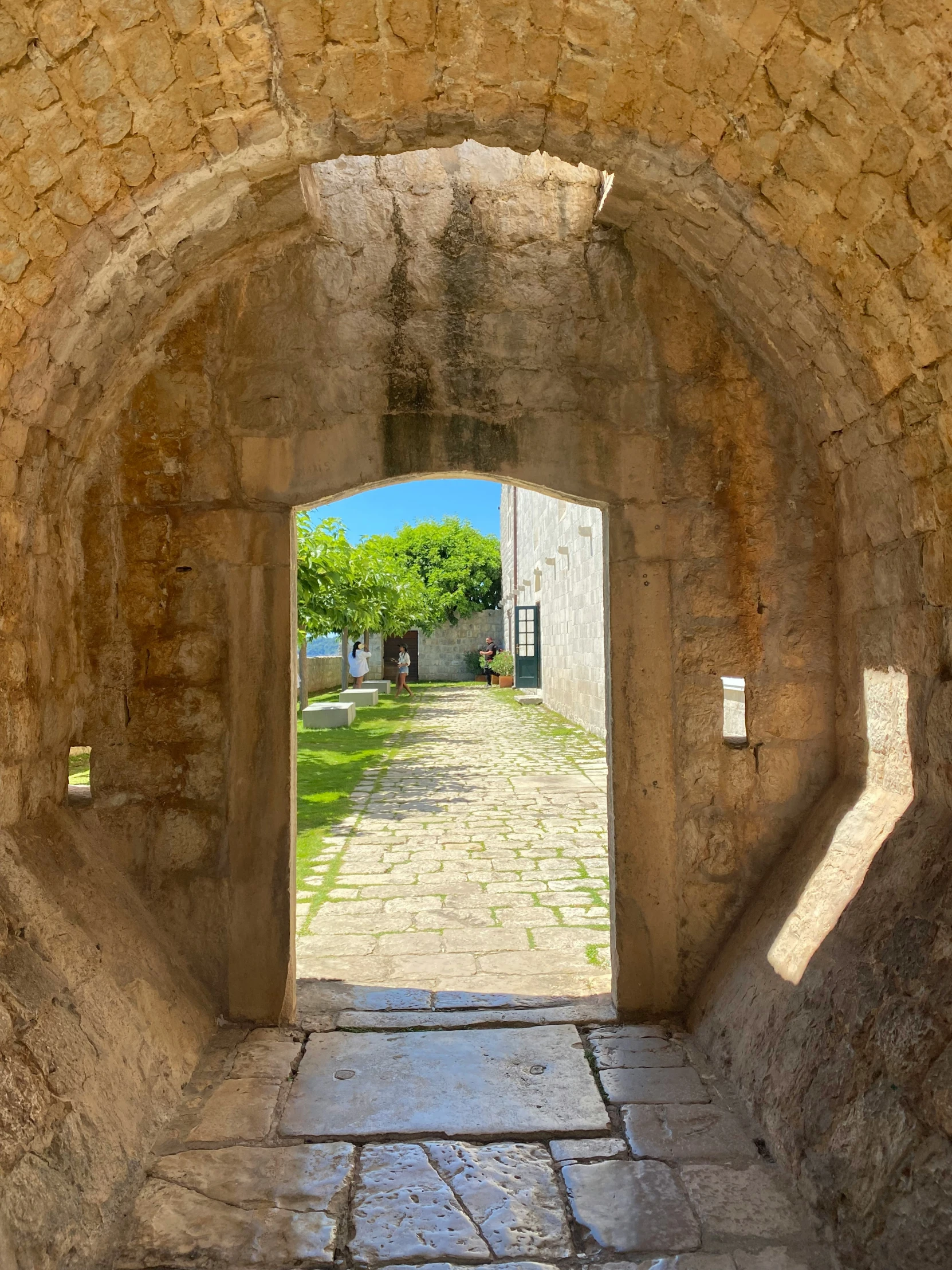 a stone archway in an old street surrounded by stone walls