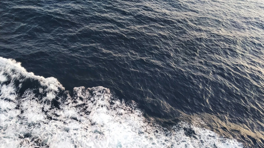 water, dark blue sea, and white ocean waves from top view