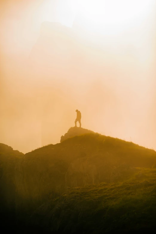 a lone hiker on the mountaintop in the sun