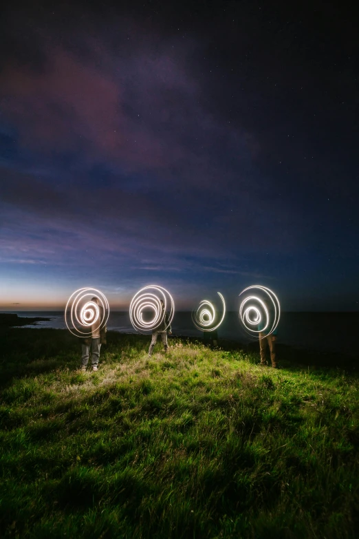 people standing on the grass holding torches in their hands