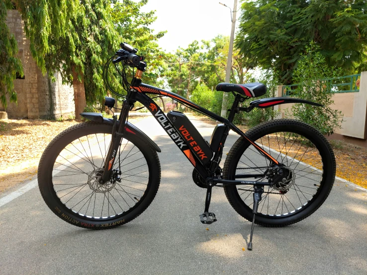 a black bicycle parked on the side of a road