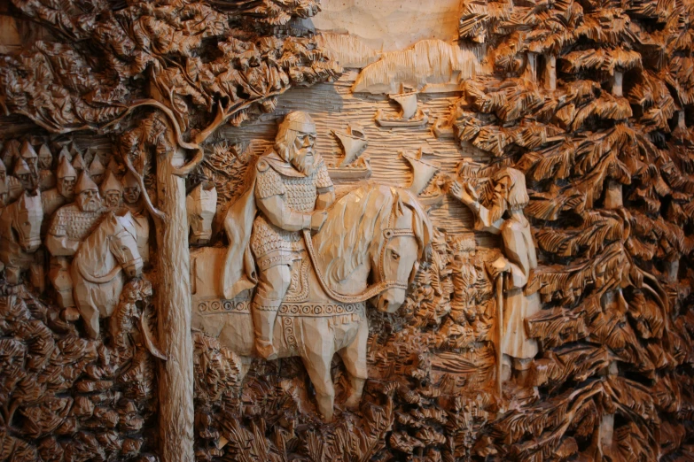 a carved wood plaque with the scene of a man on horseback