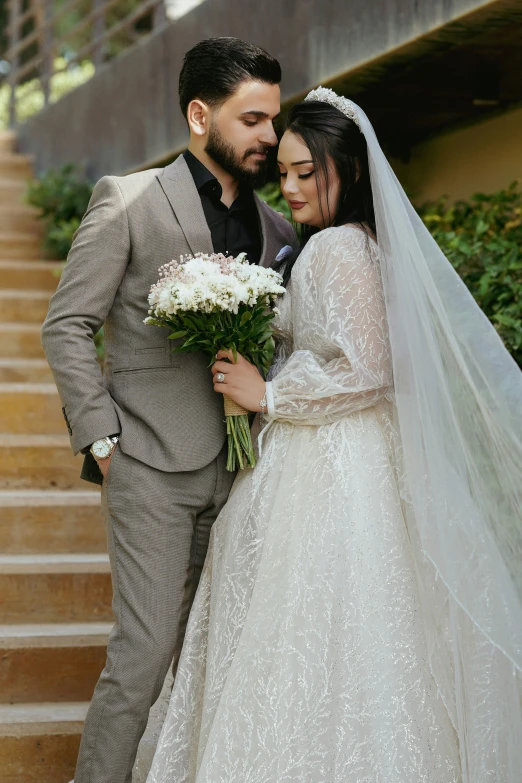 a bride and groom standing on stairs dressed in white at their wedding