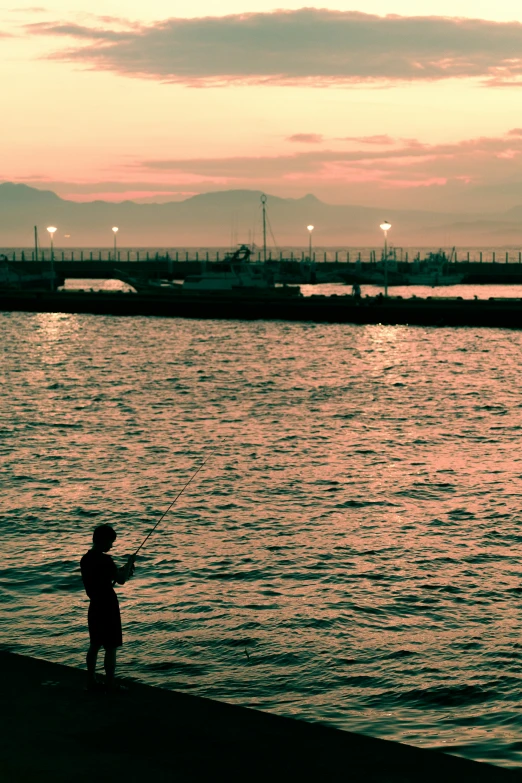 there is a man that is flying a kite by the water