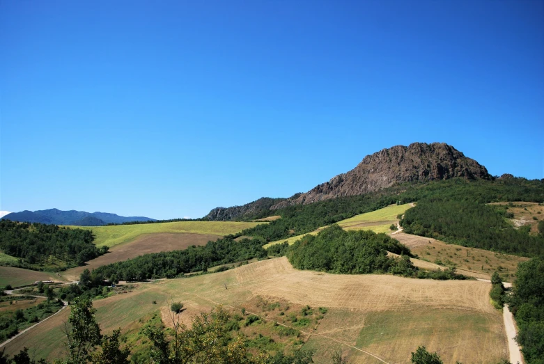 a grassy hill with a road winding through it