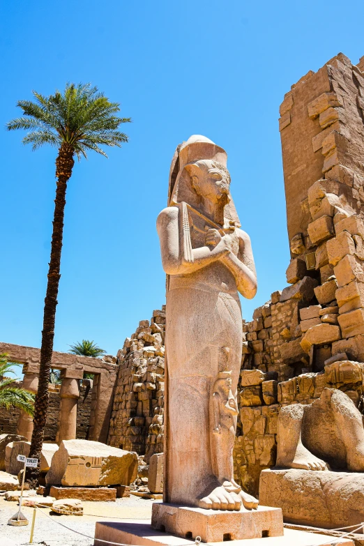 a statue sits outside the egyptian temple