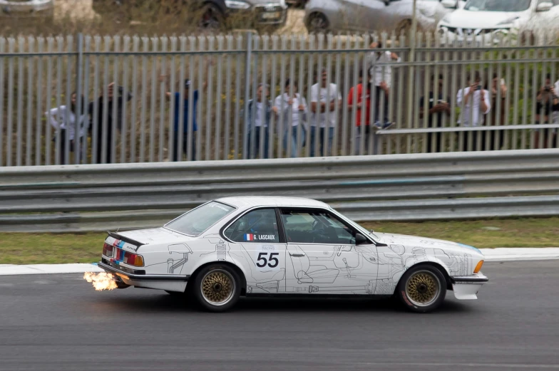 a car that has flames in the back as it speeds along a road