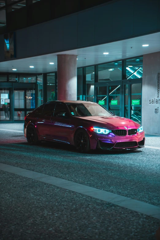 a purple and red car on the road next to a building