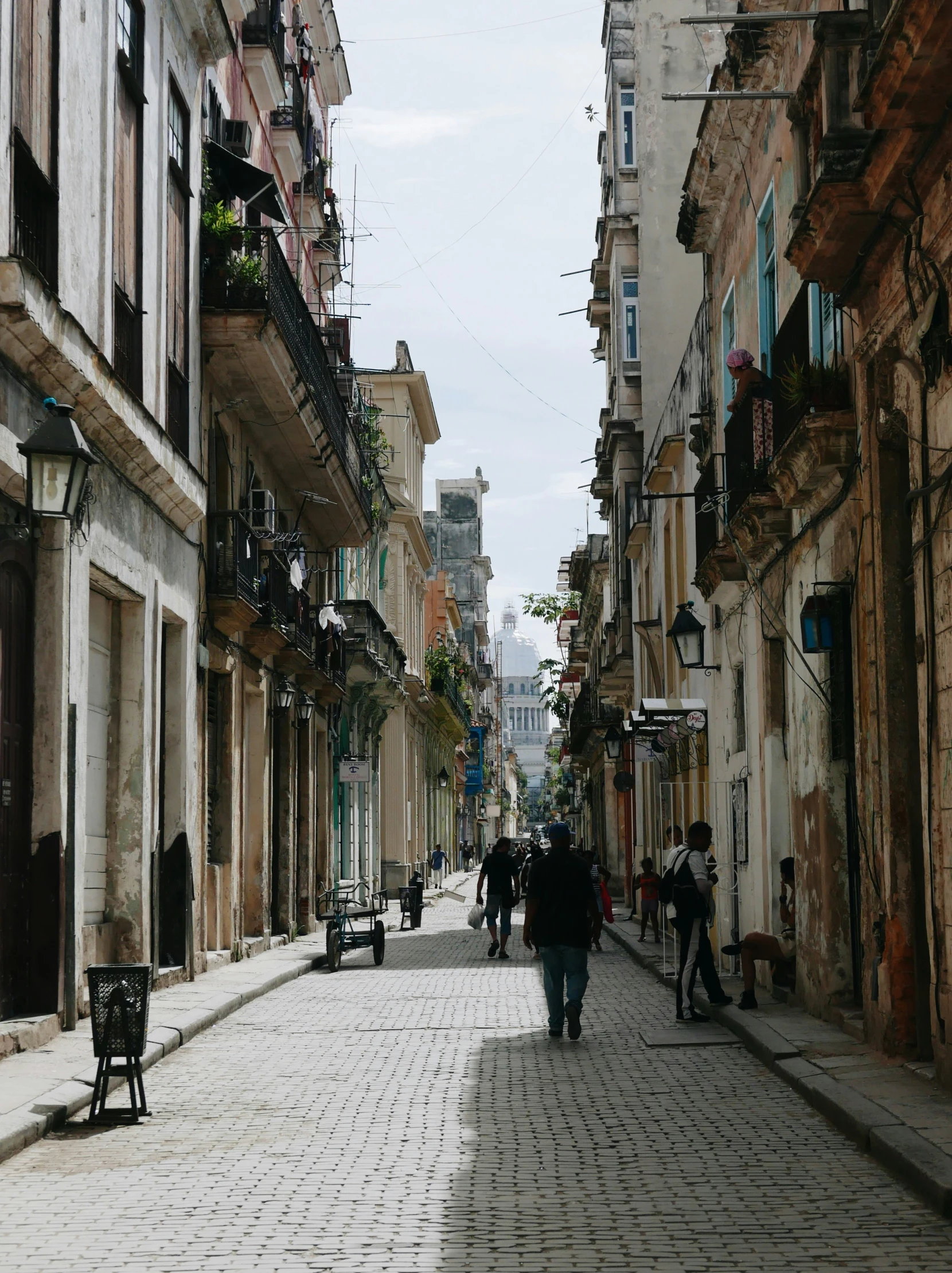 many people walk down the street in front of buildings