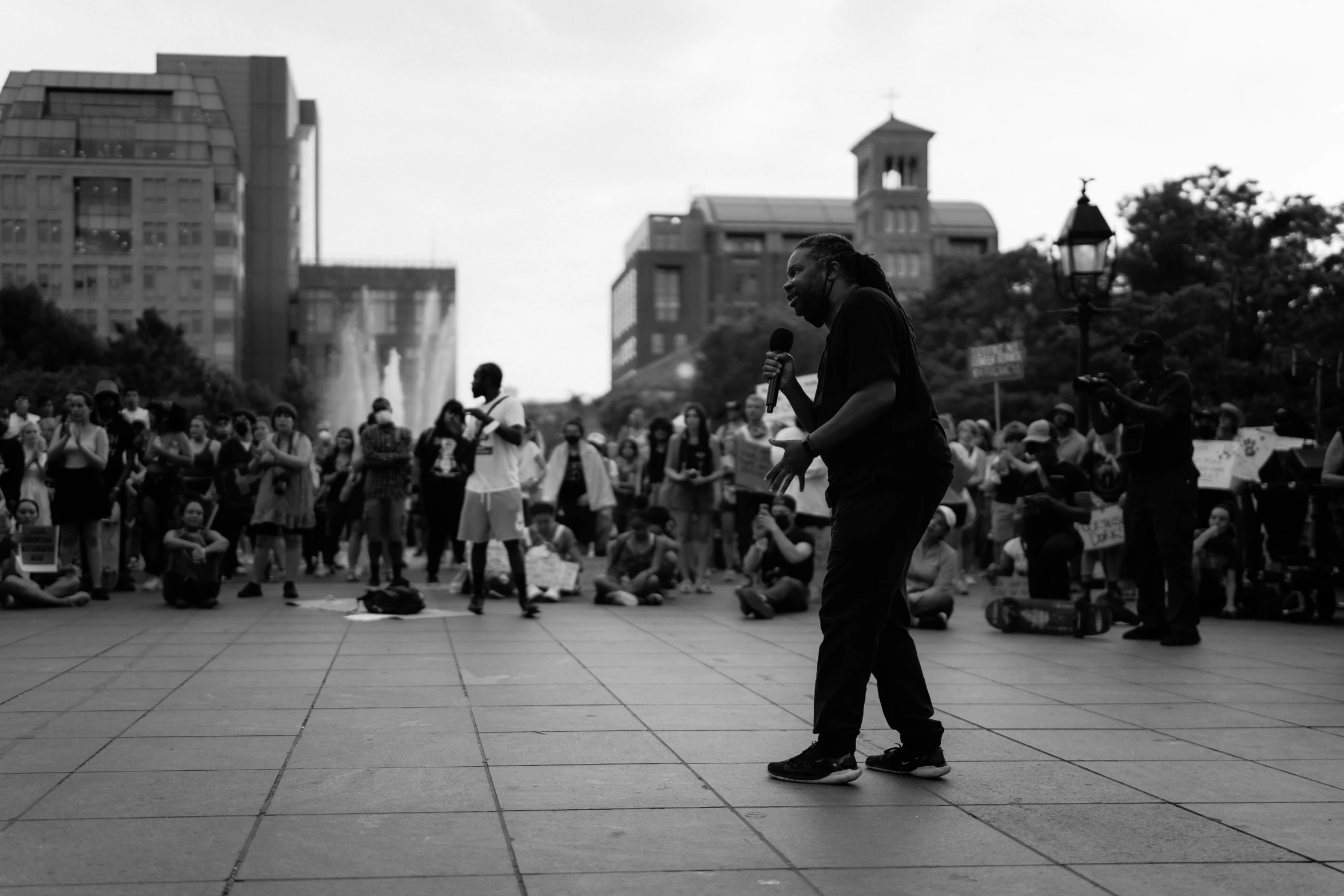 a crowd watches as the man speaks in front of the speaker