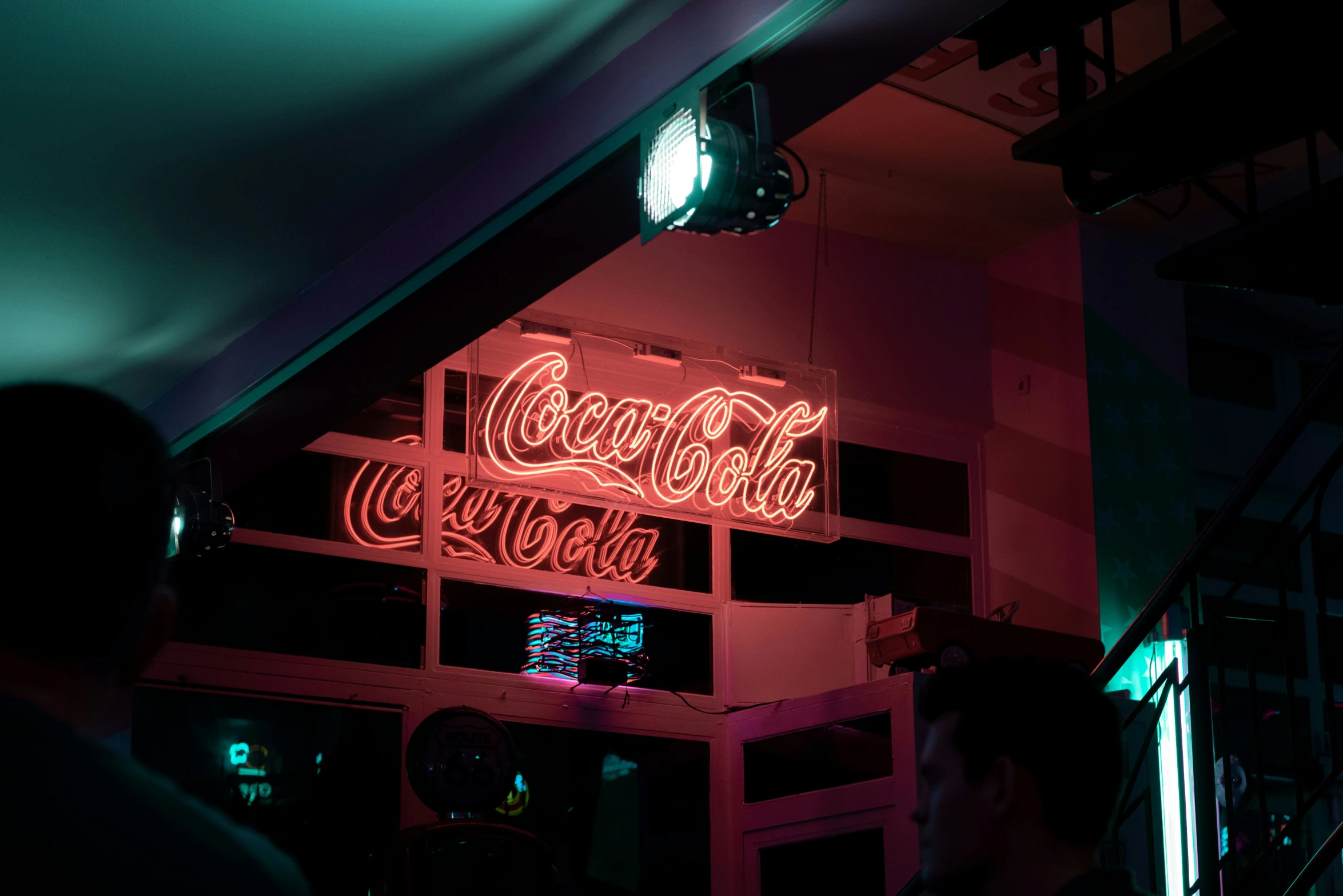 an illuminated coca cola sign above a neon bar