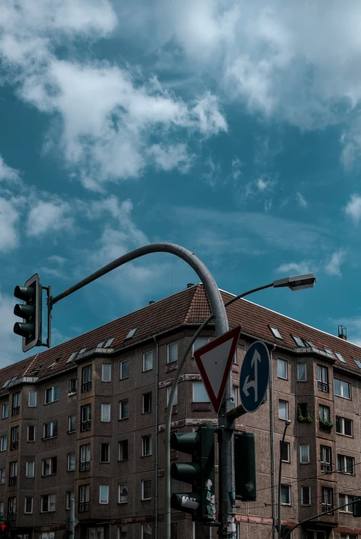 a stoplight and street sign against a cloudy sky