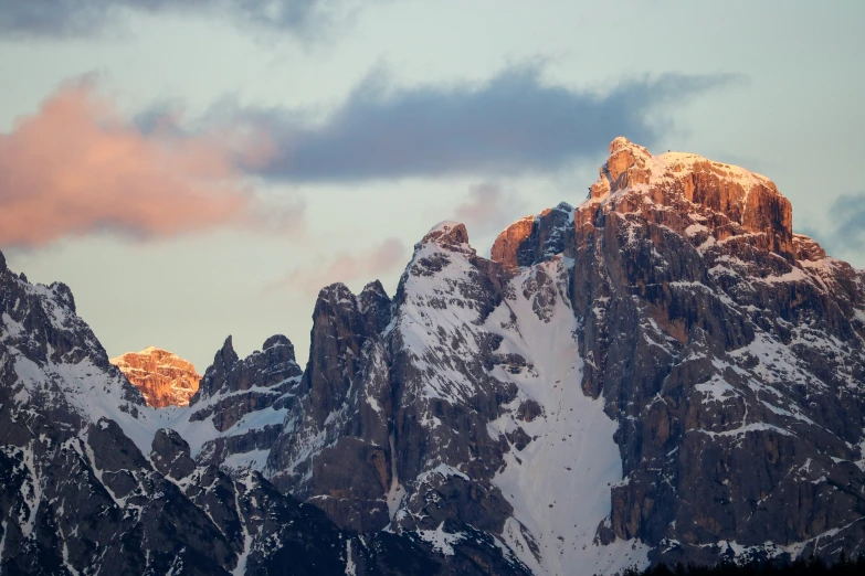 a beautiful mountain with snow and a cloudy sky