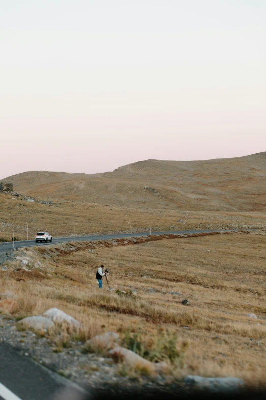 two people are walking in a field near an airplane