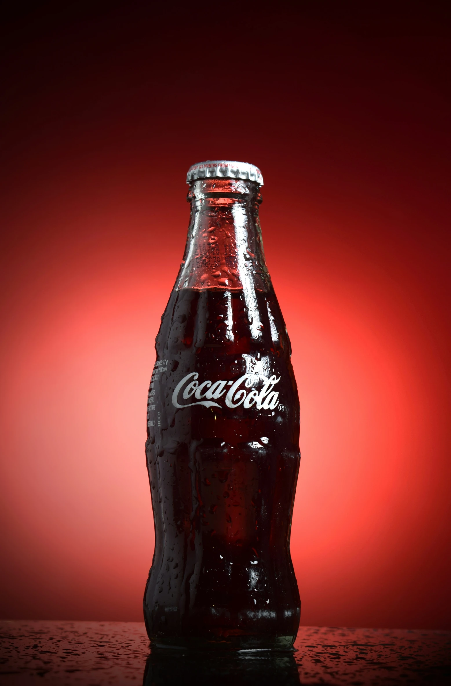 a coke bottle on a table with a red background