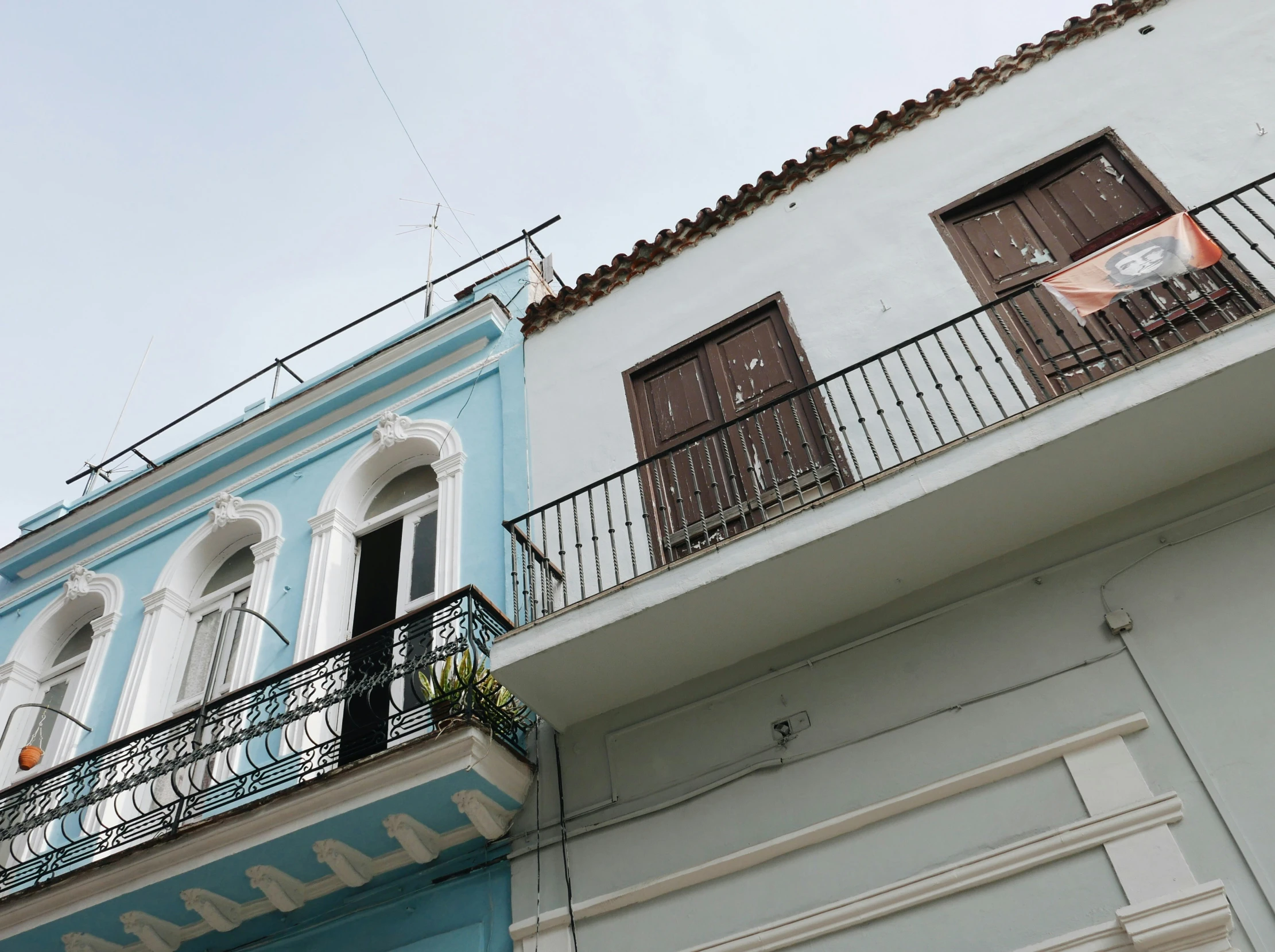 a street scene with focus on the top of two colorful buildings