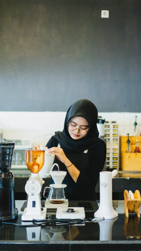 a person sitting at a table pouring tea