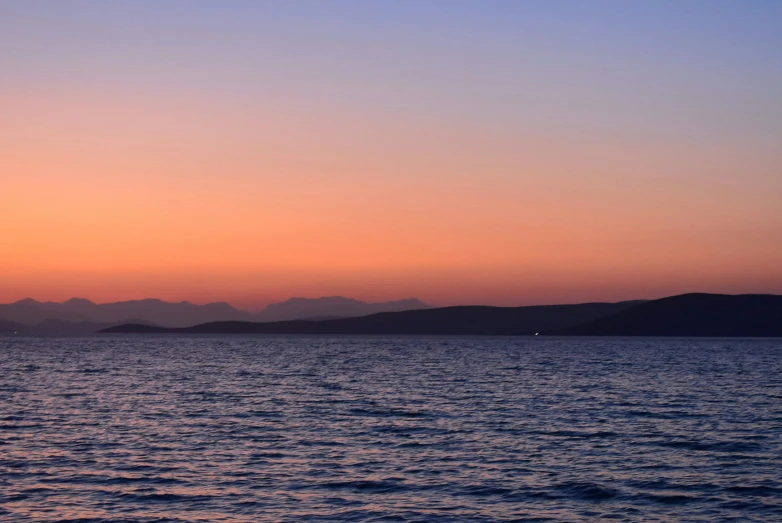 the sky is lit up over the ocean