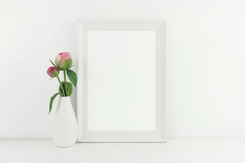 vase with flowers and mirror in front of wall