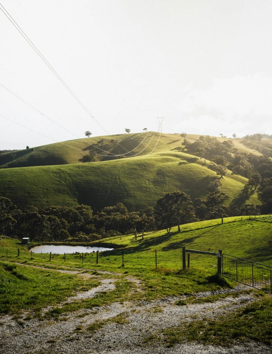 a view of green hills on top of it, some grass in the foreground