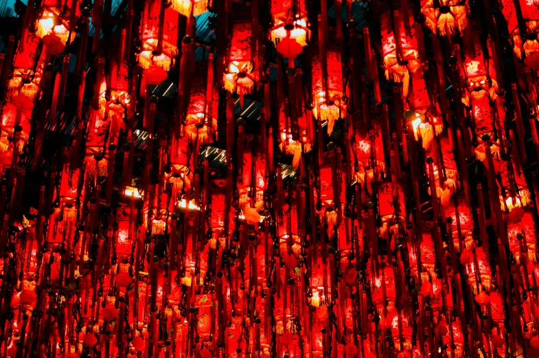 the wall is covered in red lights and some lights are hanging on them