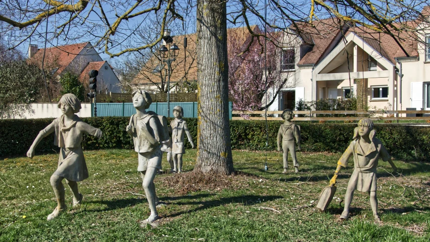 many statues stand in the grass next to trees