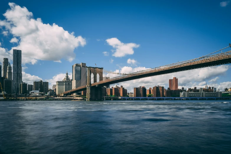 a bridge is shown over the water, with tall buildings in the background