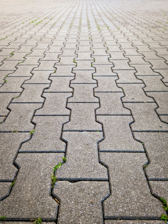 there is an empty sidewalk with small bricks in the ground