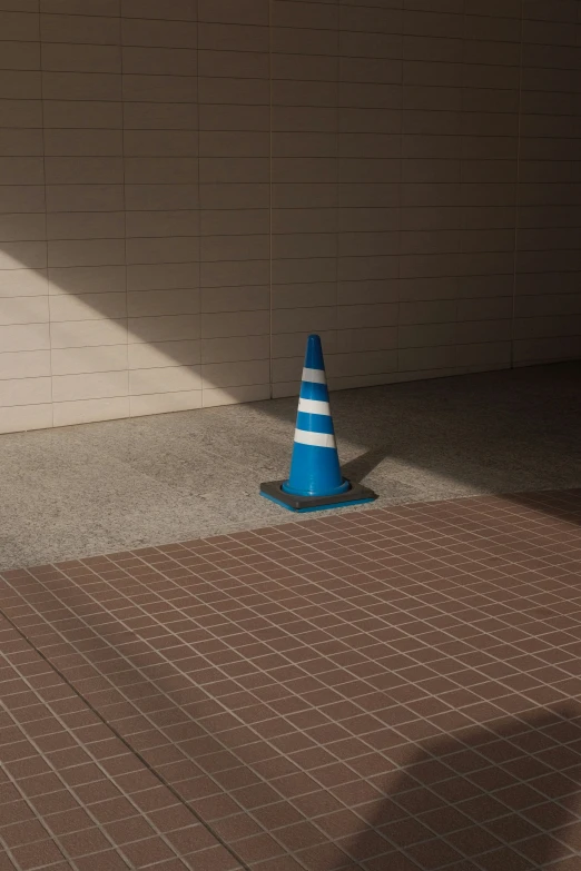 there is a cone sitting on the ground next to the wall