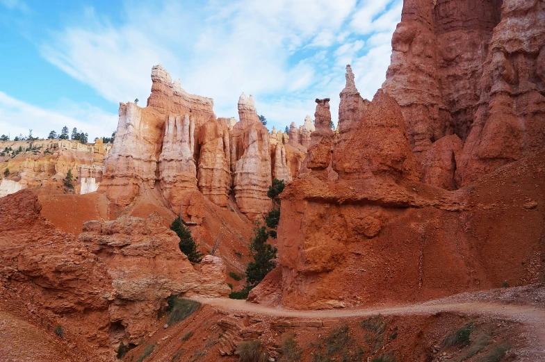 a desert scene with a path that runs between the large and small mountains