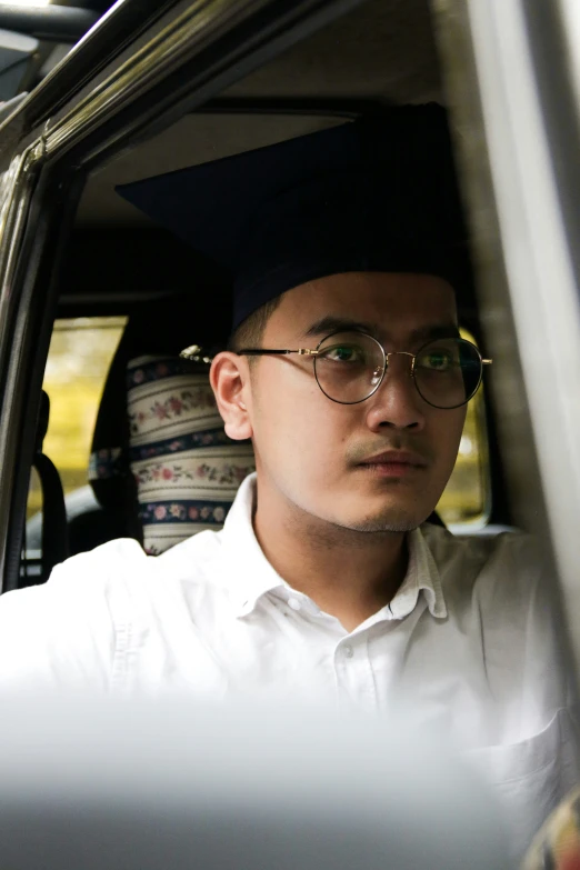 an asian man in a black cap wearing glasses