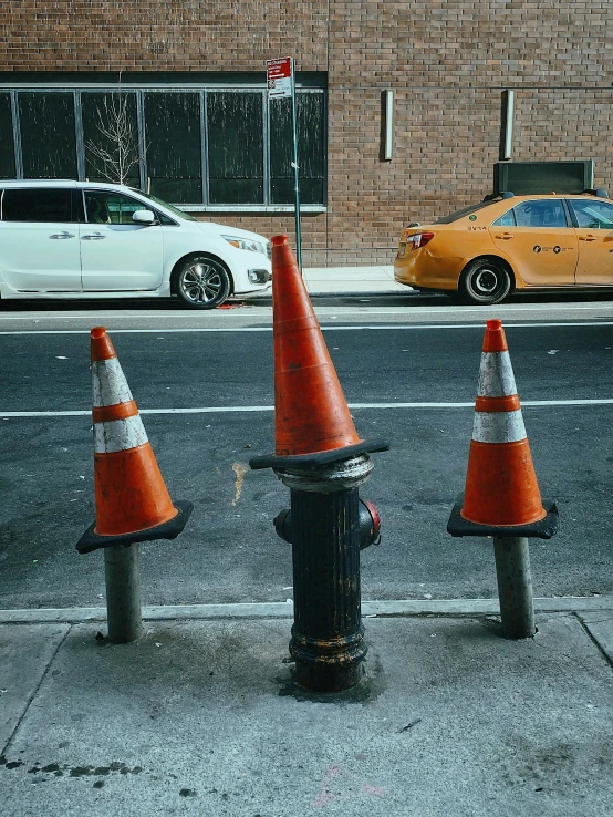 two orange traffic cones next to a fire hydrant