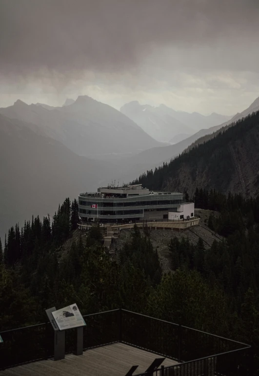 a mountain with a building and mountain range behind it