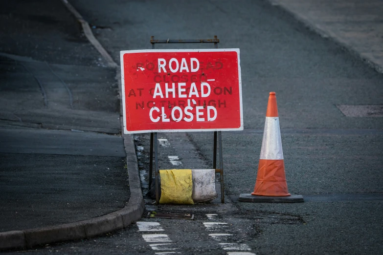 a sign with road ahead is closed in the middle of the street