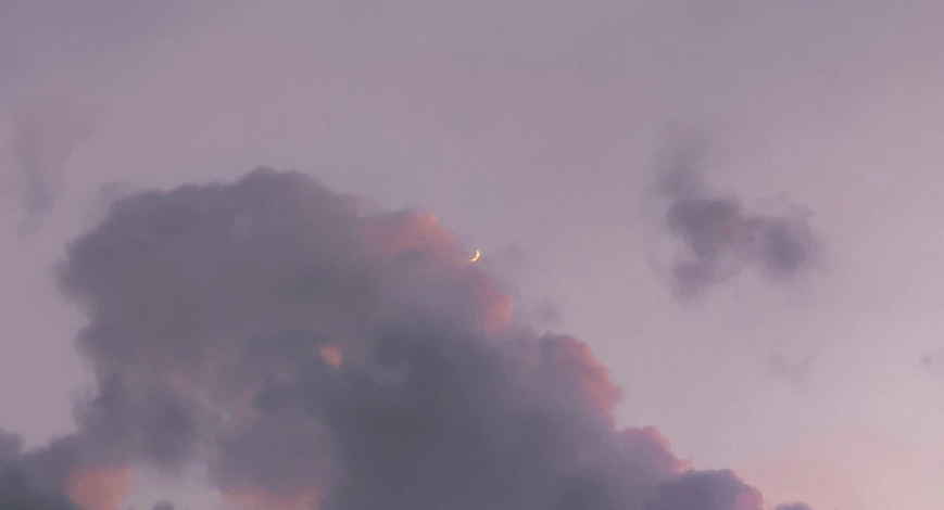 a large airplane flying in the sky near clouds