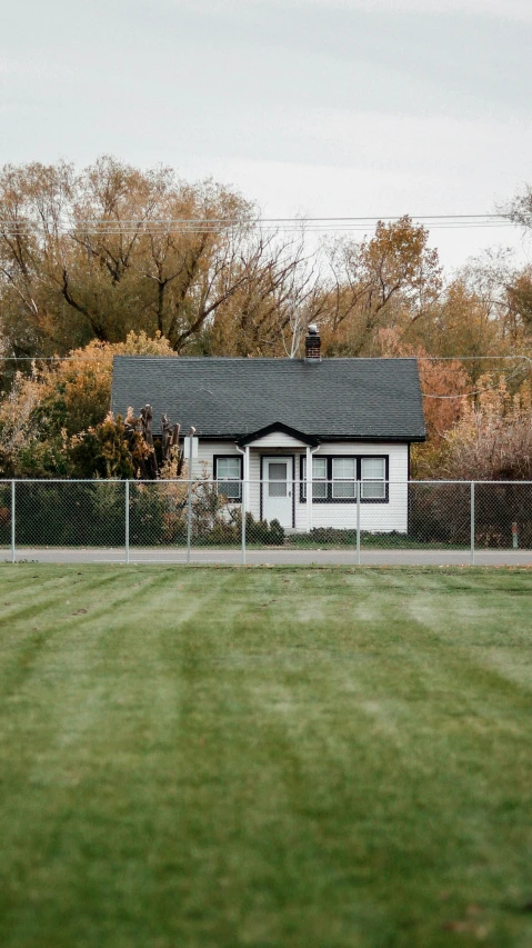 a small house with a metal fence around it