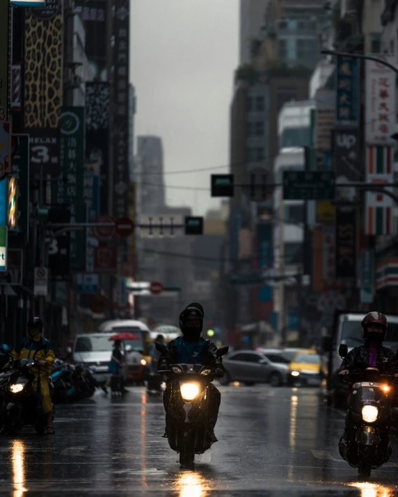 motorcycles drive through the city with rain on the road